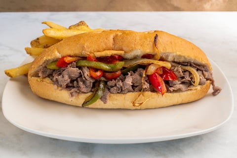Shredded steak with onions and peppers in a sub roll