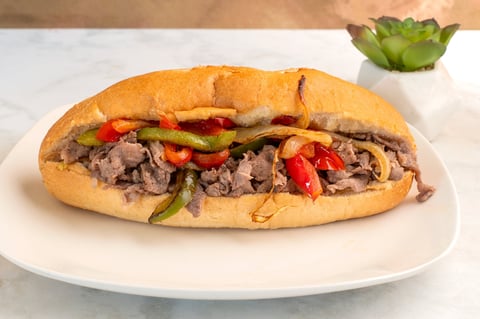 Shredded steak with onions and peppers in a sub roll