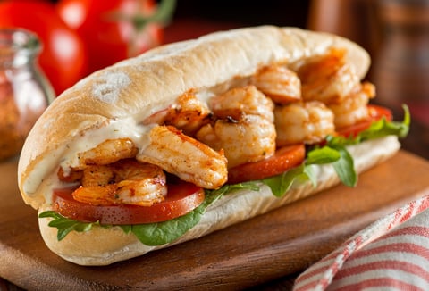 A delicious homemade spicy shrimp sandwich with lettuce, tomato, and tartar sauce