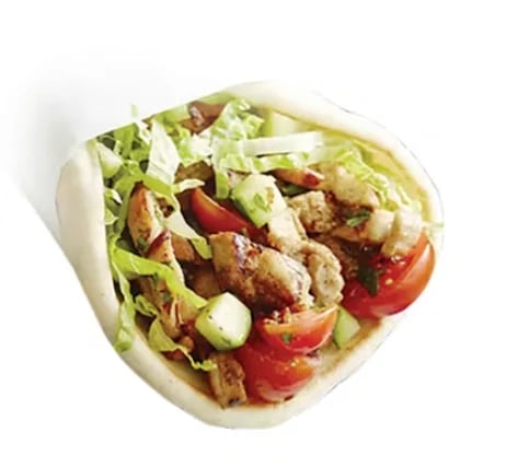 Pita wrap filled with grilled chicken, fresh lettuce, sliced tomatoes, and crumbled cheese