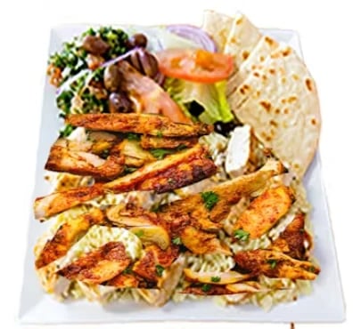 Grilled chicken shawarma platter with seasoned meat, pita bread, fresh salad, and hummus on white plate